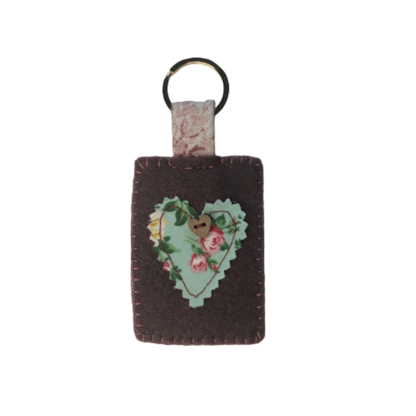 Μπρελόκ κλειδιών, από τσόχα και υφασμάτινη καρδιά απλικέ, σε χρώμα μελιτζανί και φλοράλ σε αποχρώσεις του πράσινο-ροζ με διακοσμητικό κουμπί καρδιά - καρδιά, μπρελόκ, αγ. βαλεντίνου